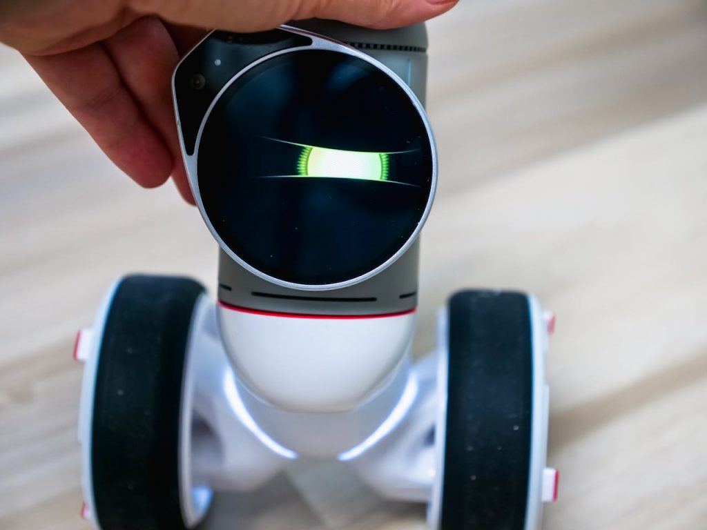 Detailed view of a wheeled robot being touched, showcasing tactile interaction.